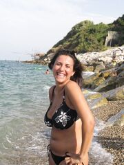 Tettona in  bikini e topless in spiaggia