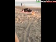 Coppia italiana scopa in spiaggia in pieno giorno