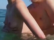 Coppia nudista scopa in spiaggia in vacanza