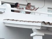 Due ragazze ballando in topless sul balcone