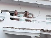 Due ragazze ballando in topless sul balcone