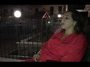 Italiana si rilassa fumando un sigaro sul balcone