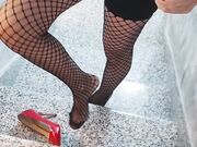 Senza slip in calze a rete e tacchi a spillo