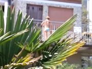 Milf in bikini si spalma la crema in terrazza