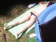 Vicina di casa prende il sole in topless in giardino