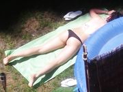 Vicina di casa prende il sole in topless in giardino