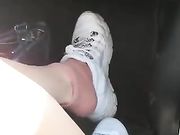 I miei piedi sudati in macchina in scarpe da tennis