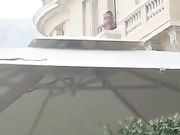 Aperitivo in piazza con coppia che scopa sul balcone