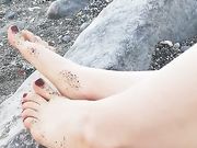 Ragazza italiana mostra i suoi piedini in spiaggia