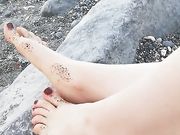 Ragazza italiana mostra i suoi piedini in spiaggia