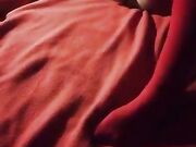 Si masturba sul letto in autoreggenti rosse