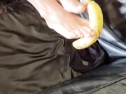 Si toglie le calze e gioca coi piedi con la banana